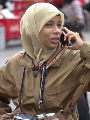 Young Muslim Woman Chats on Cellphone - Outside Retribution Museum - Jakarta - Indonesia