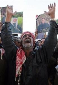 A man shouts 'God is great' as demonstrators in background