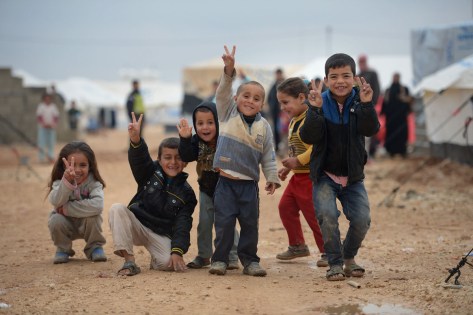 ZA'ATARI, JORDAN - FEBRUARY 01: Children pose for a picture as Syrian refugees go about their daily business in the Za'atari refugee camp on February 1, 2013 in Za'atari, Jordan. Record numbers of refugees are fleeing the violence and bombings in Syria to cross the borders to safety in northern Jordan and overwhelming the Za'atari camp. The Jordanian government are appealing for help with the influx of refugees as they struggle to cope with the sheer numbers arriving in the country. (Photo by Jeff J Mitchell/Getty Images) ORG XMIT: 160600686