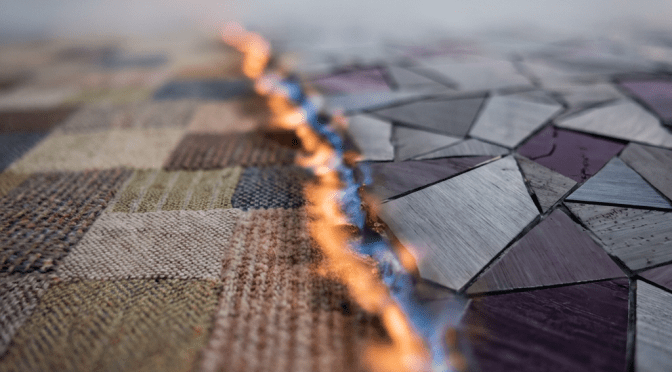 A line of orange and blue fire divides a checkered rug and a purple mosaic surface.