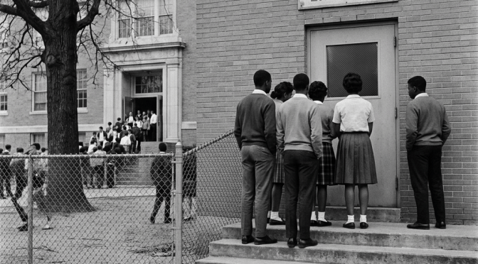 Students outside a school entrance labeled “NON-WHITE STUDENTS ENTRANCE”